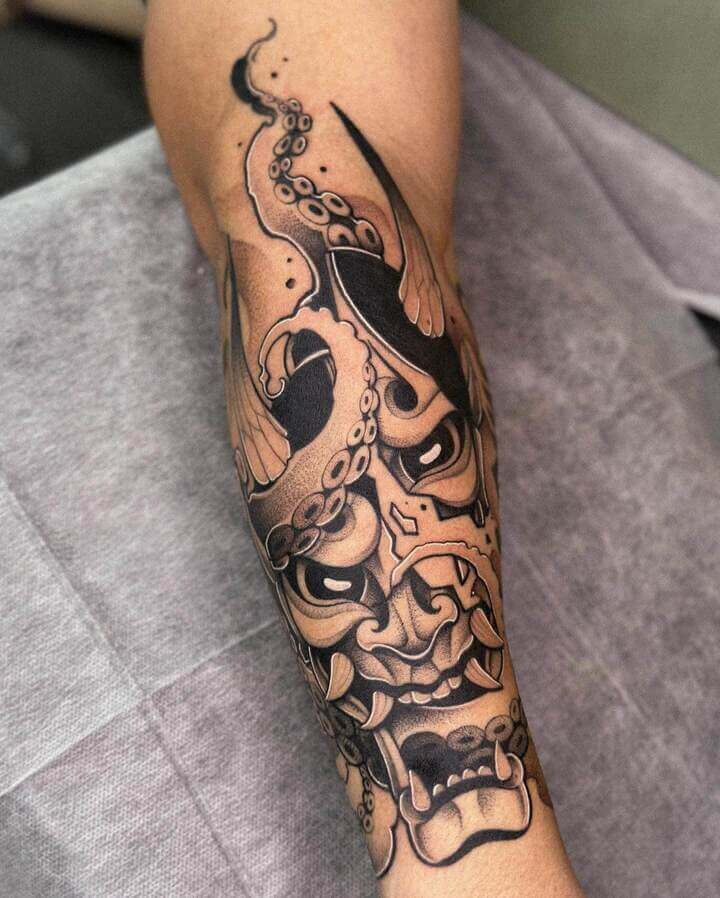 forearm demon mask tattoo